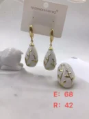 jpg31ERGOLD PERFORATED FLORAL DETAL WITH WHITE CERAMIC AND GOLD LEAF DROP EARRING AND MATCHING RING